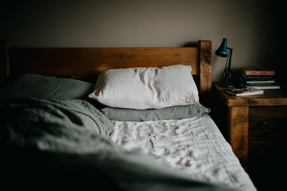 a bed with a wooden headboard and a night stand