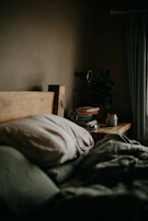A serene bedroom nook with organic cotton bedding, a bamboo lamp, and a small stack of eco-conscious books.