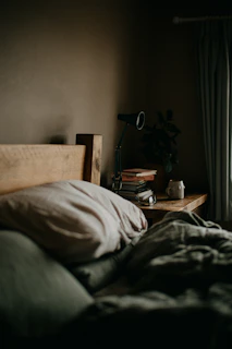 A cozy bedroom setup showcasing a neatly made bed with soft linens and a rustic wooden headboard.