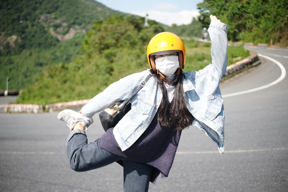 a woman wearing a yellow helmet is riding a skateboard