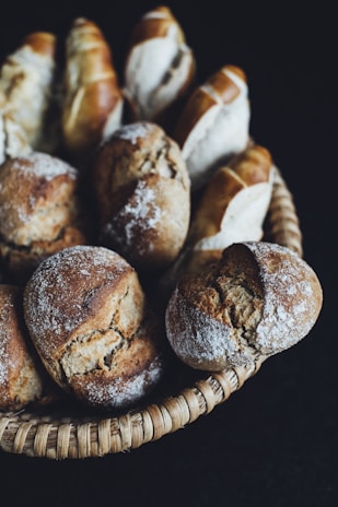 Freshly baked artisanal integral buns arranged in a basket lined with a linen cloth