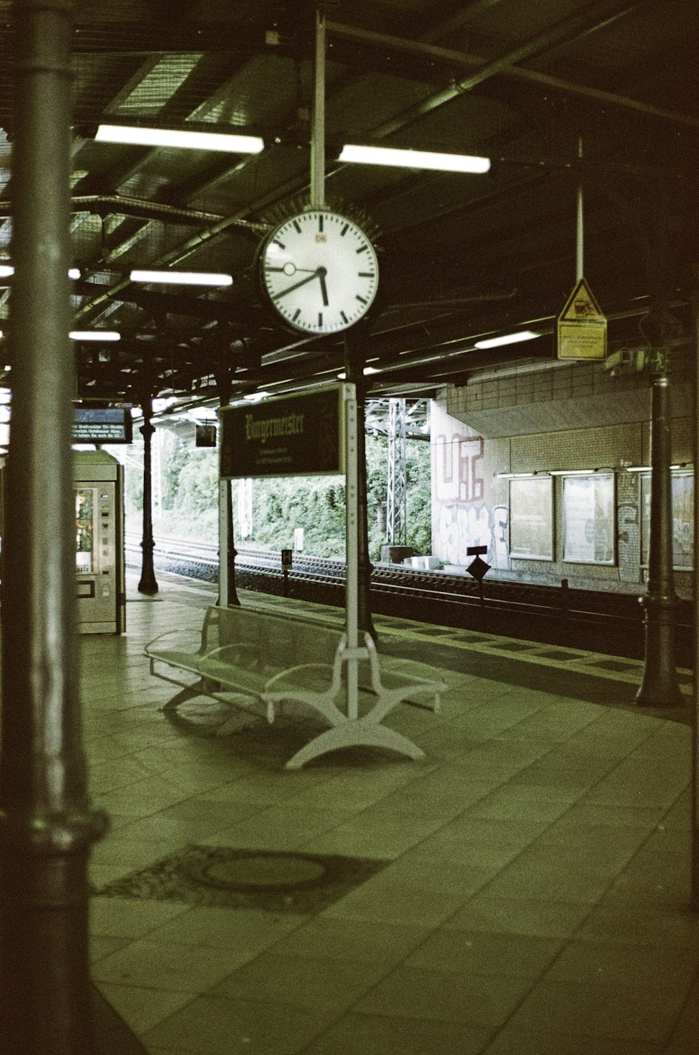 a clock on a pole in a train station