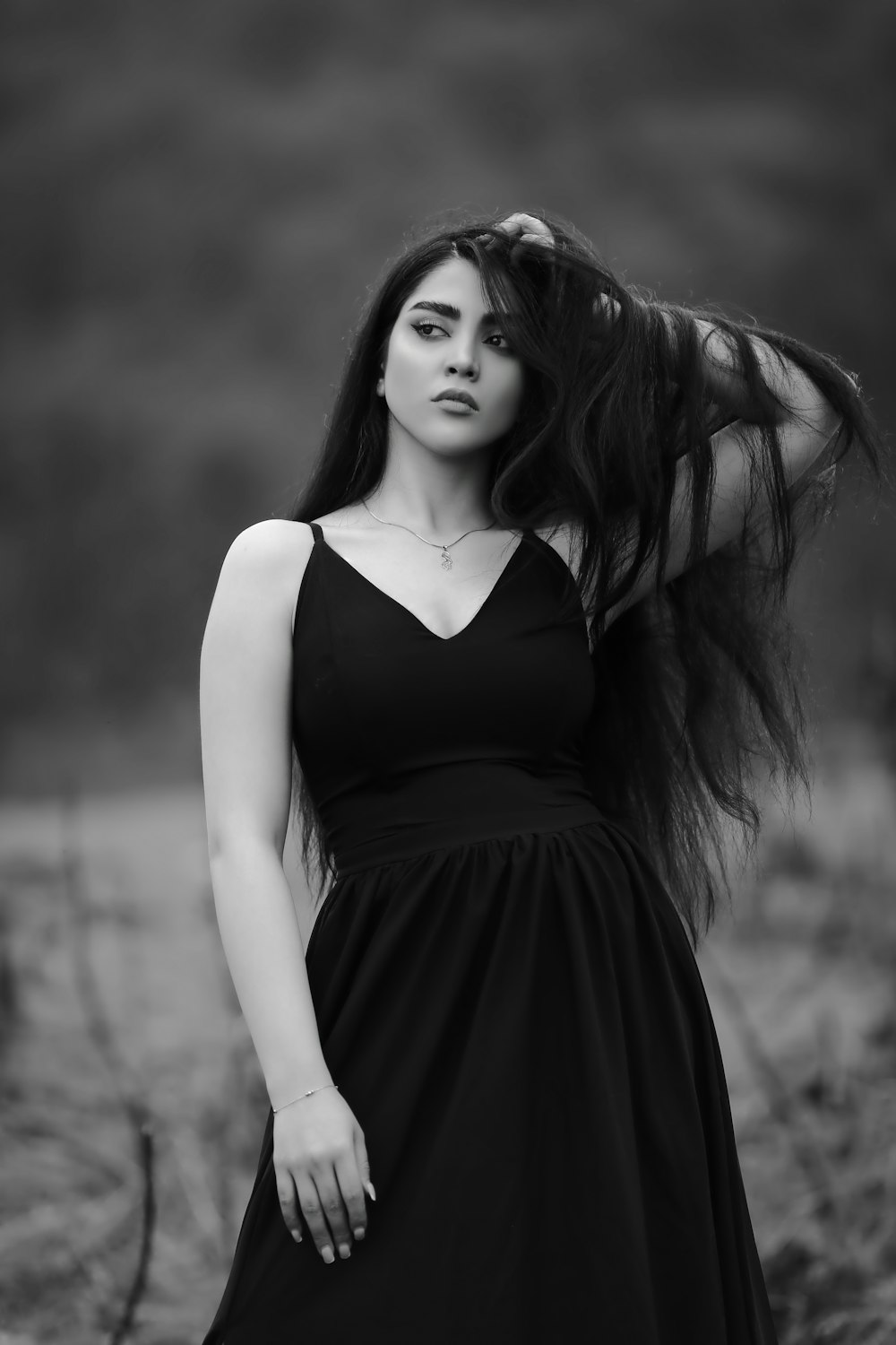 a woman with long hair standing in a field