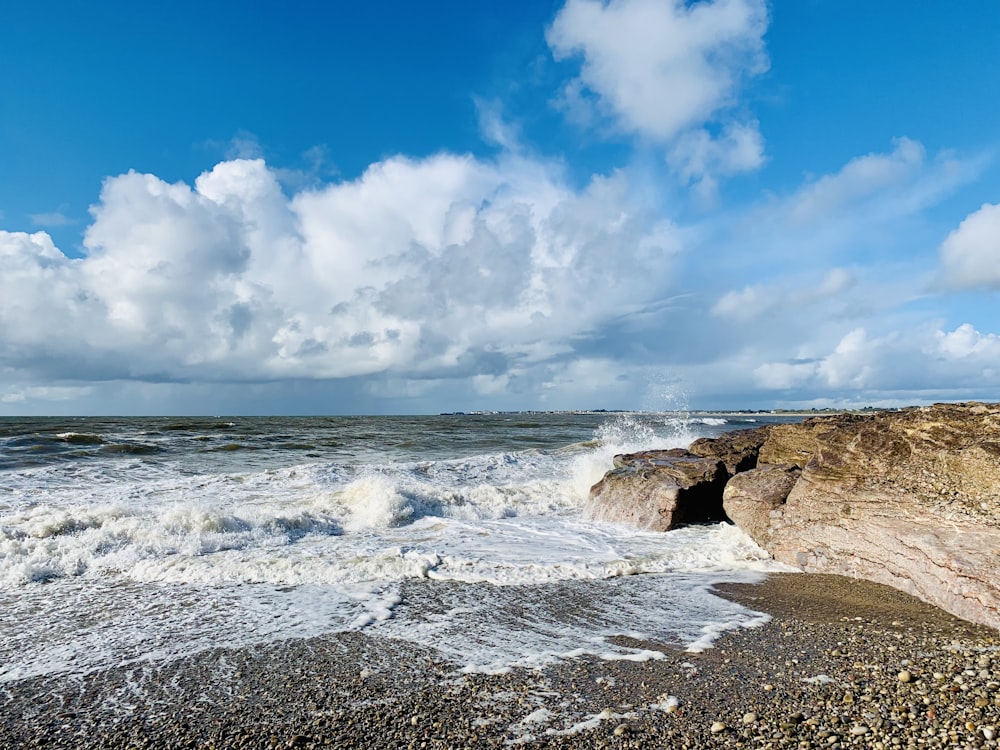 a large body of water sitting next to a rocky shore