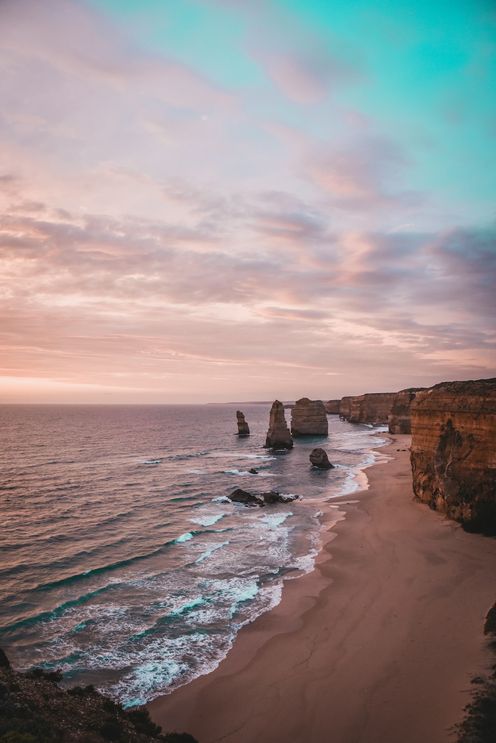 a view of a beach with a cliff in the background