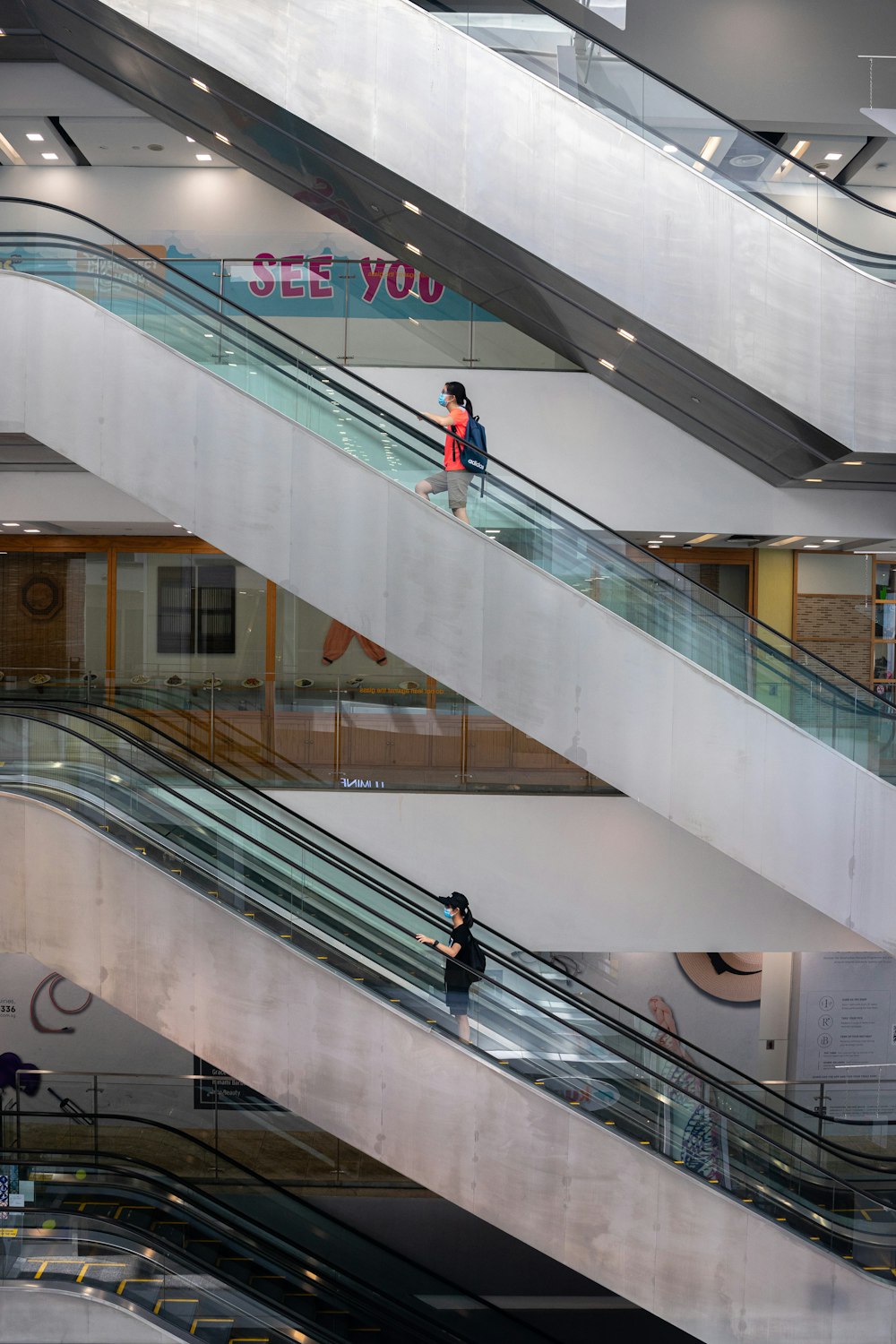 a woman is walking down an escalator in a building