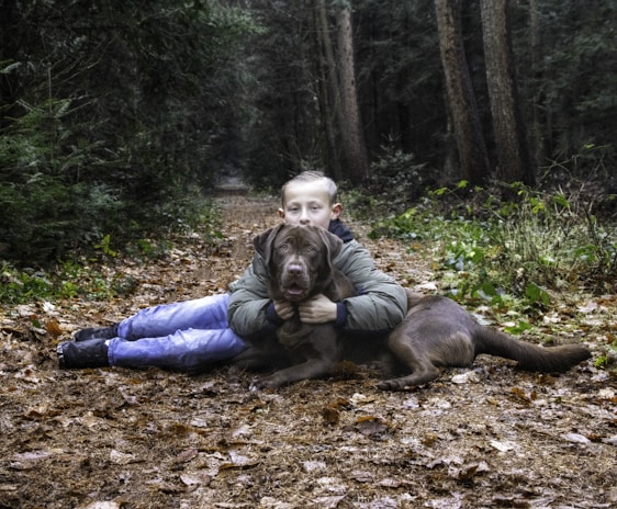 A peaceful moment of interaction between a young adolescent and a friendly therapy dog in a garden.