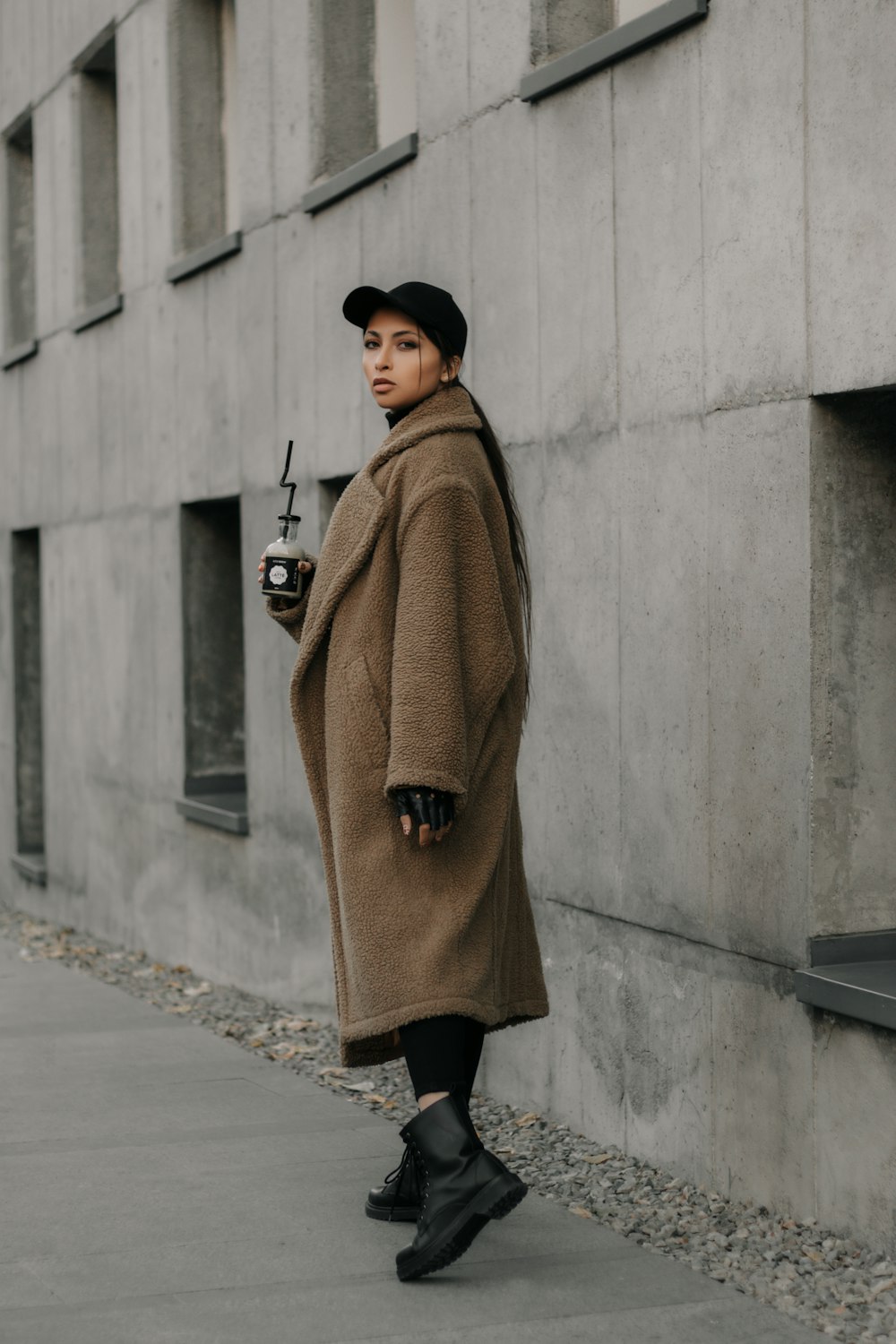 a woman in a brown coat and black boots