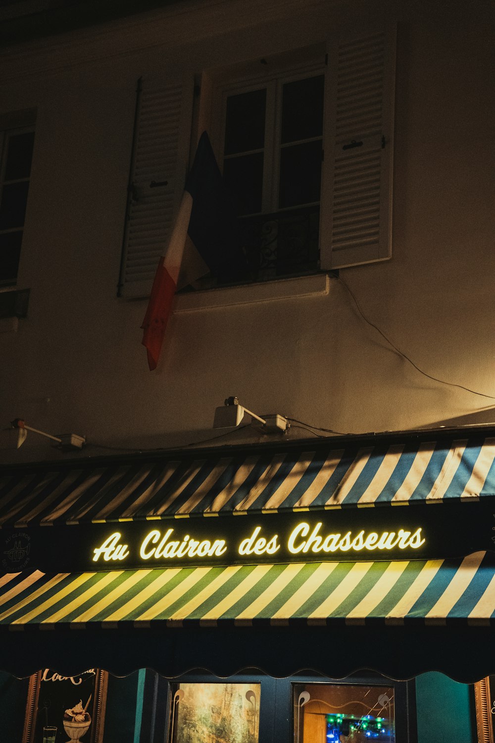 a building with a striped awning at night