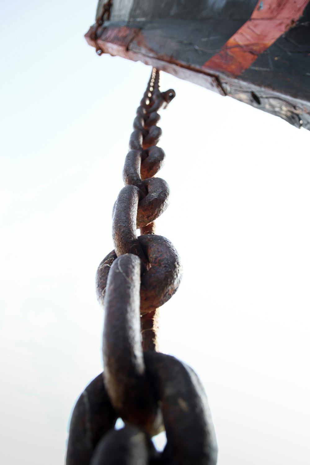 a close up of a chain with a boat in the background