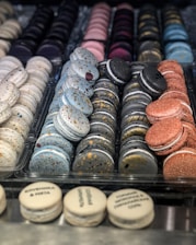 A cozy bakery counter displaying an assortment of macarons in various vibrant colors.