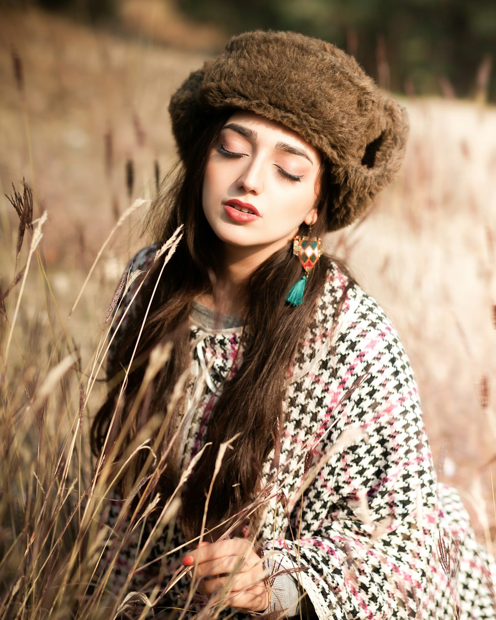 a woman in a hat is sitting in a field