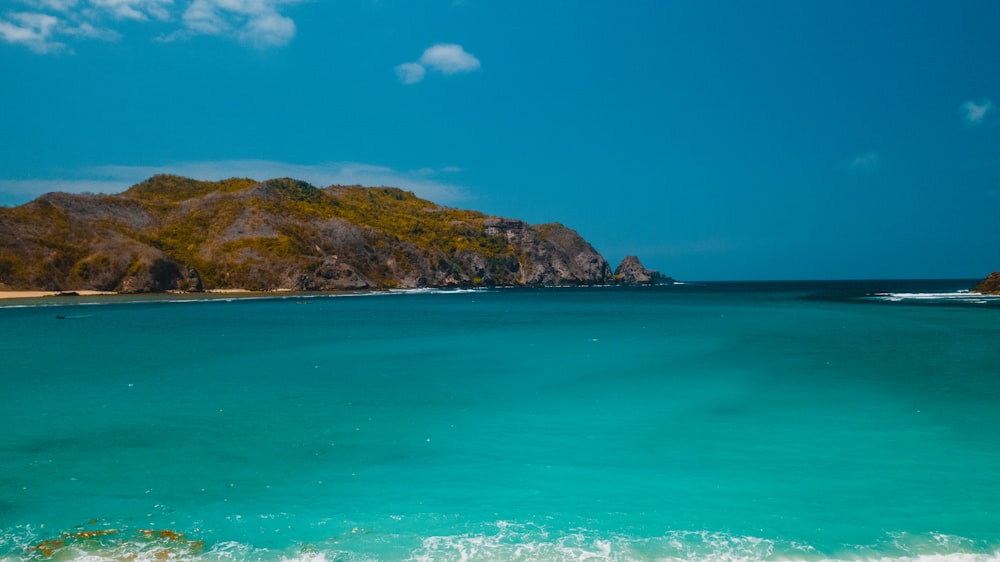 a body of water with a mountain in the background