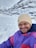 A happy customer skiing on a snowy mountain.