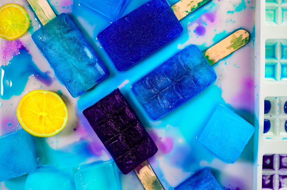 popsicles with blue and yellow toppings on a tray
