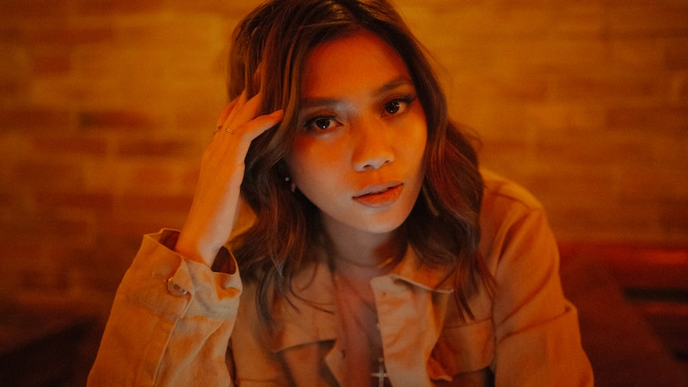 a woman sitting at a table with her hand on her head