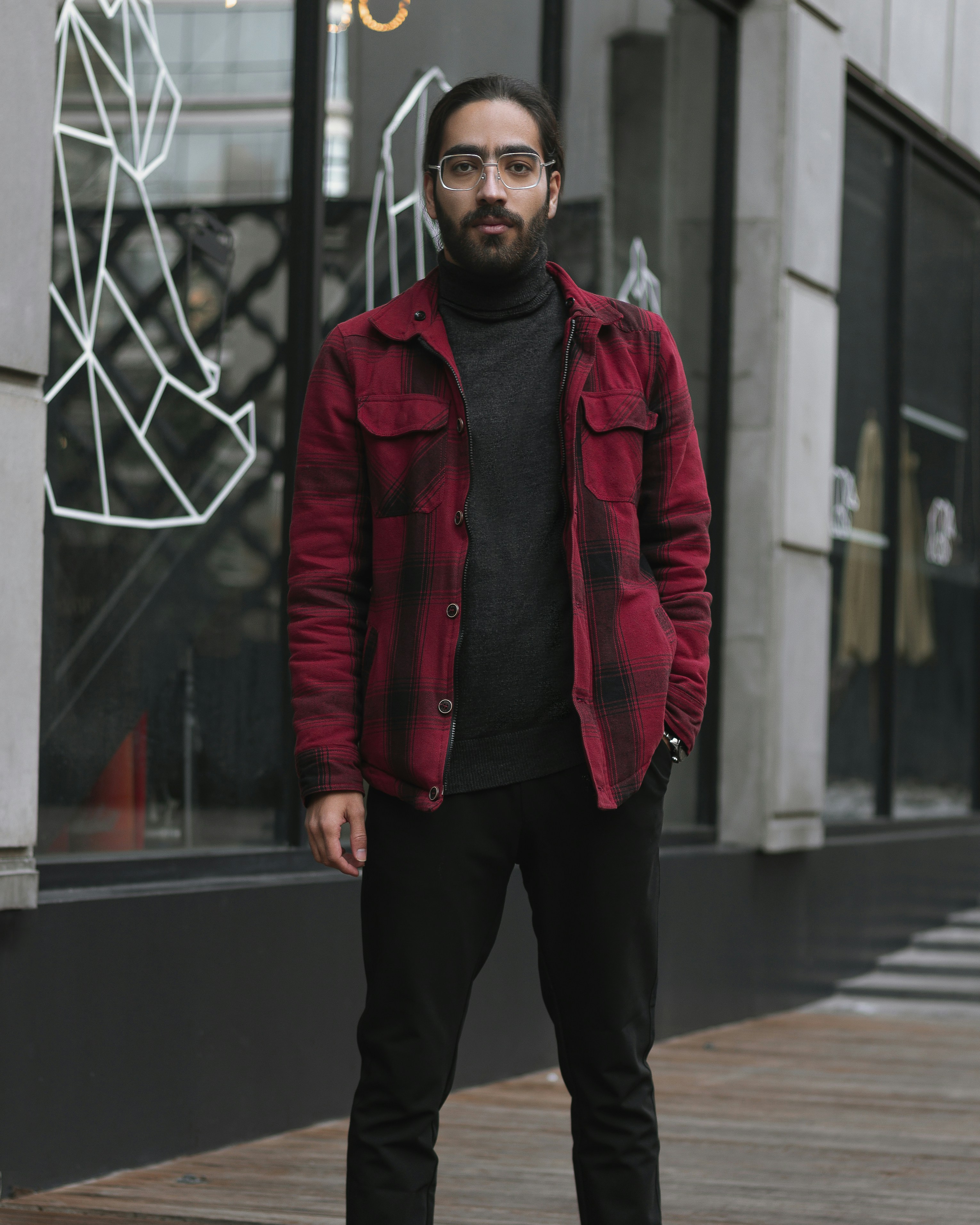 a man wearing a red jacket and black pants