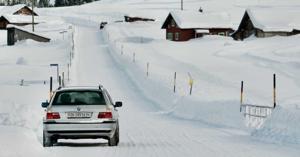 um carro dirigindo por uma estrada coberta de neve
