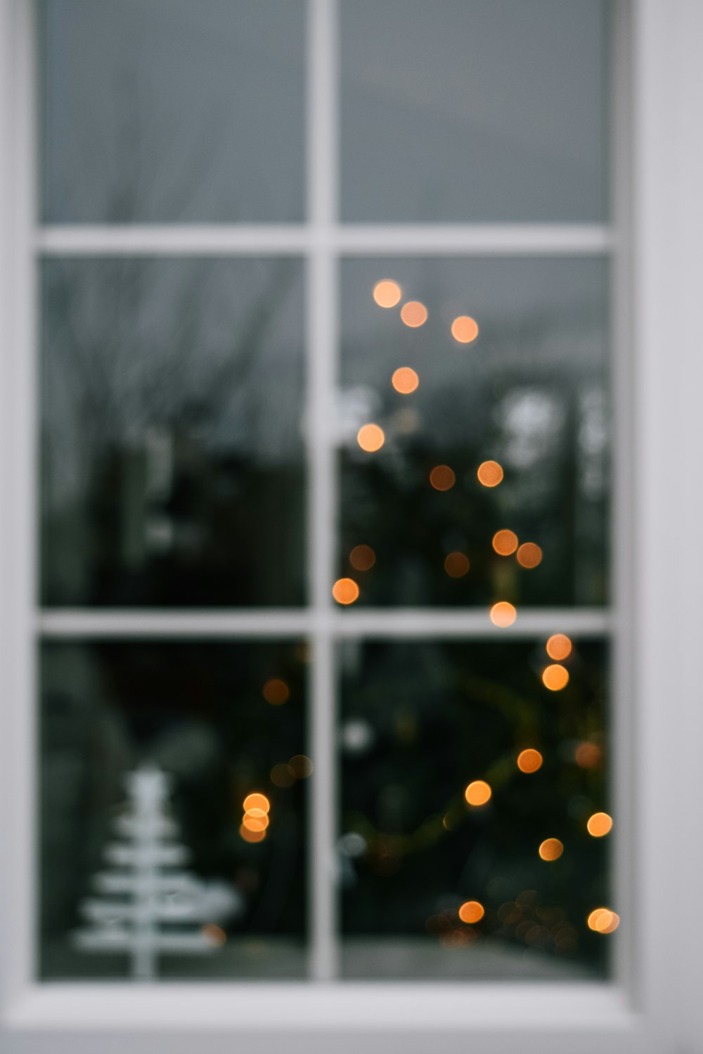 a christmas tree is seen through a window