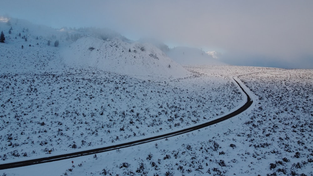 a winding road in the middle of a snow covered mountain