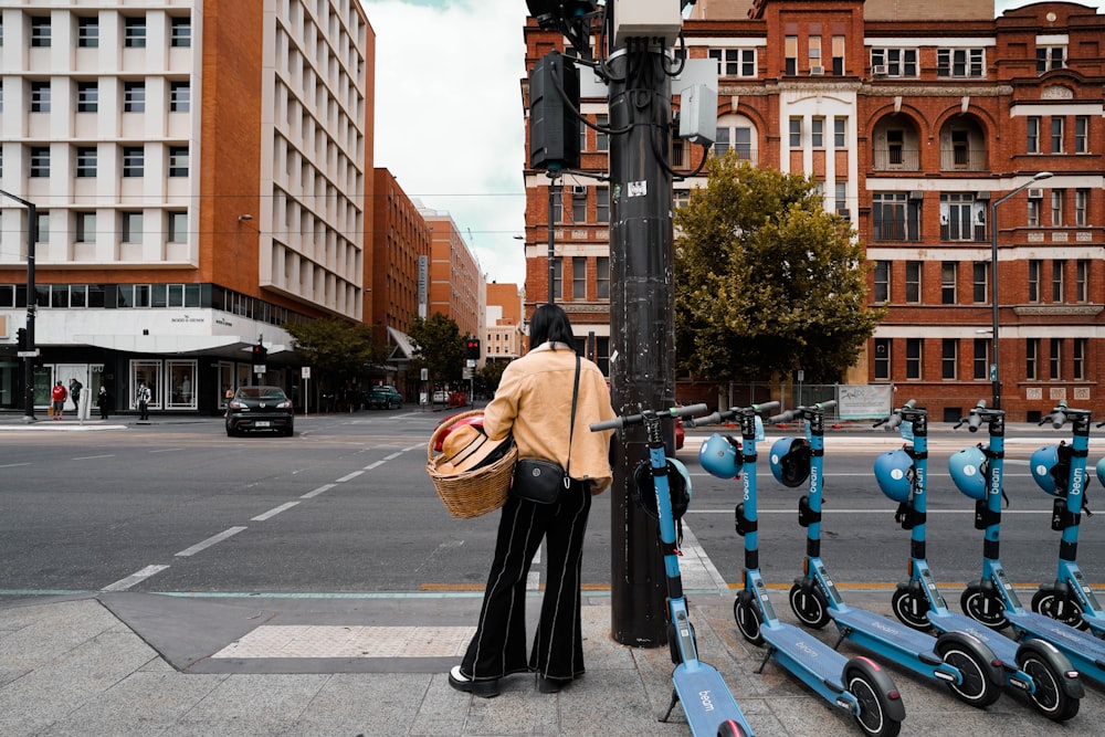 a woman standing on a street corner next to a traffic light