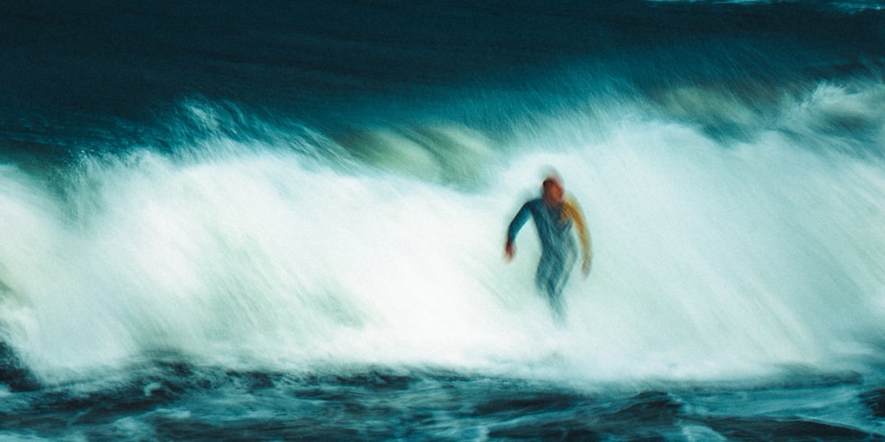 a man riding a wave on top of a surfboard