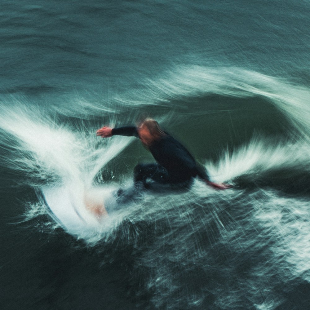 a man riding a wave on top of a surfboard