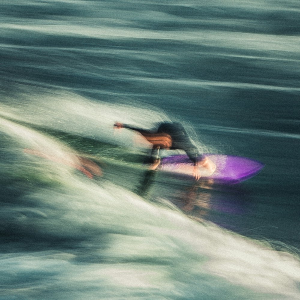 a man riding a wave on top of a surfboard