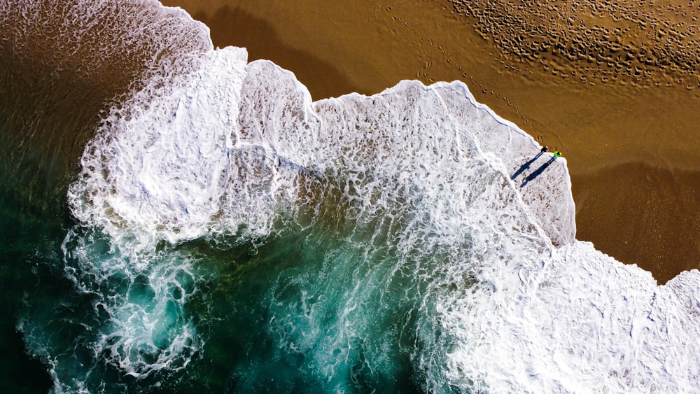 an aerial view of a person surfing on a wave