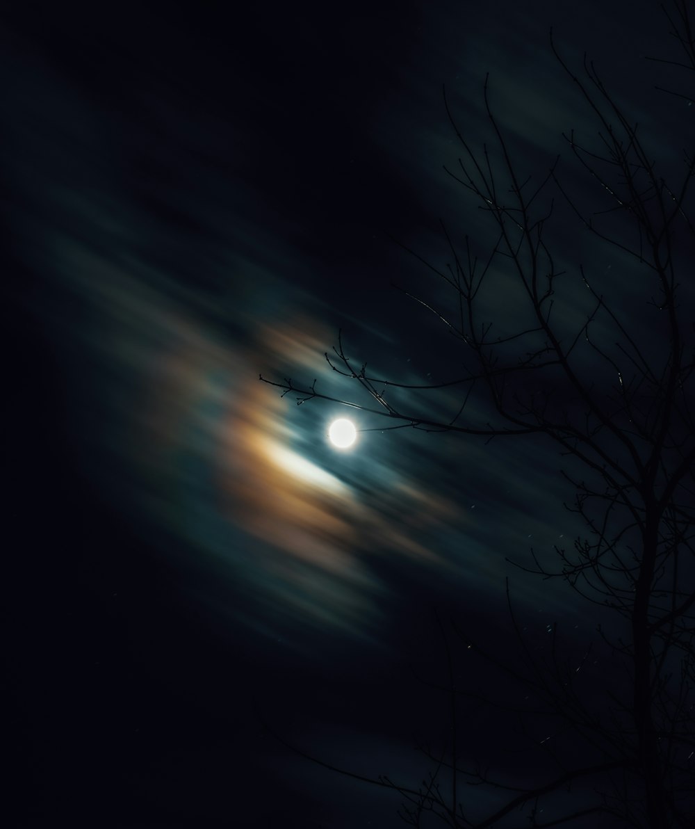 Ein Vollmond durch die Wolken am Nachthimmel gesehen