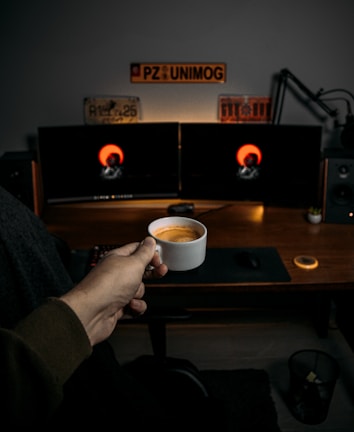 An artistic shot of a developer’s desk featuring notes on antigravity principles and a cup of coffee beside a glowing keyboard.