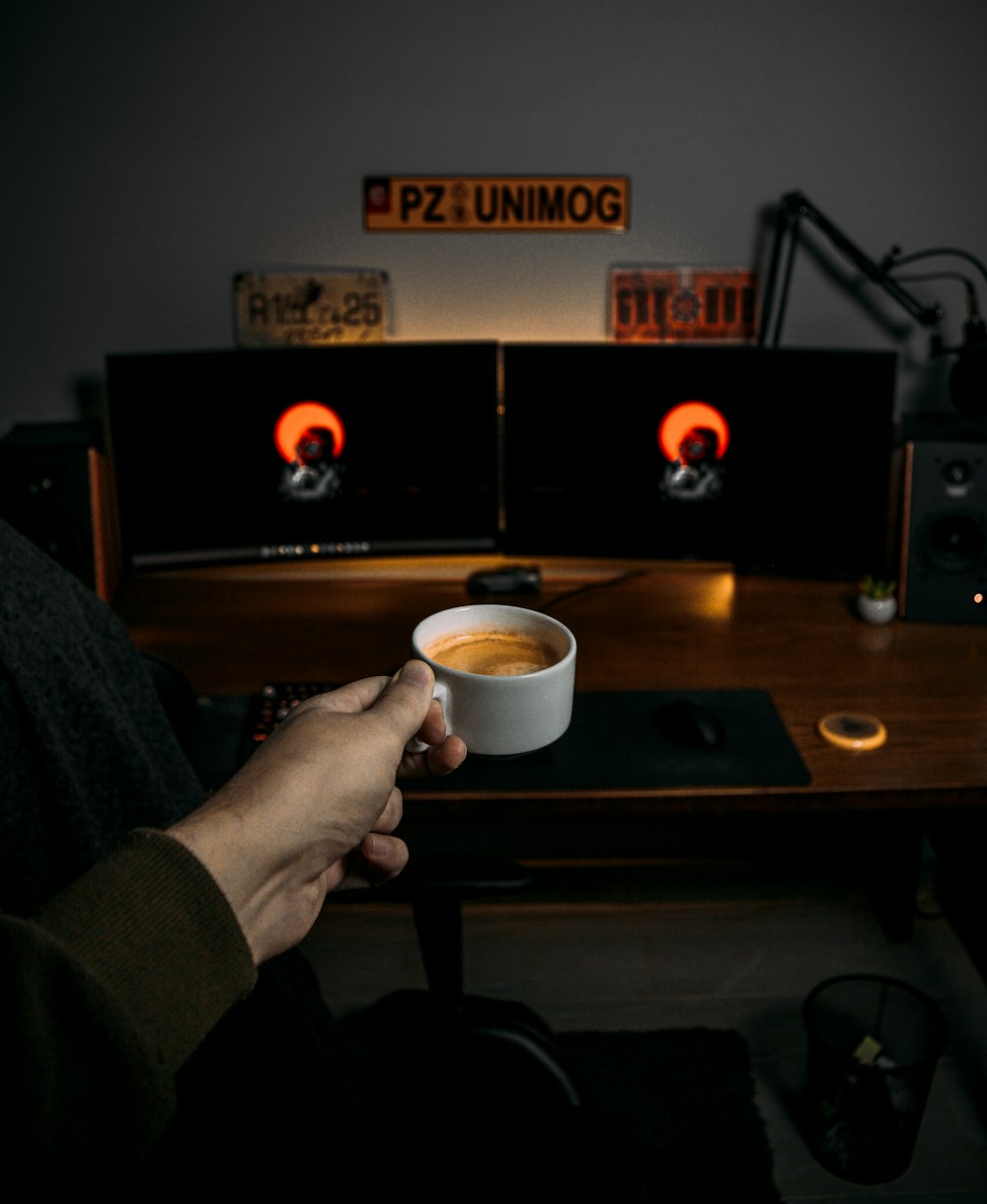 a person holding a cup of coffee in their hand