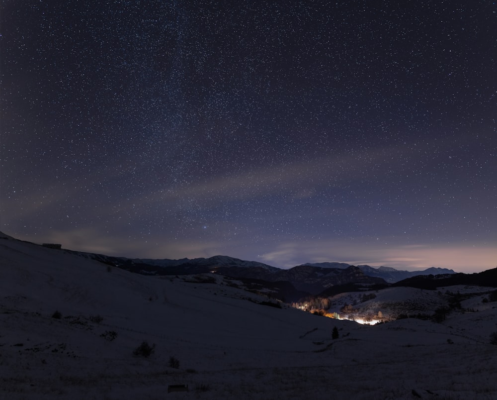 o céu noturno com estrelas acima de uma montanha nevada