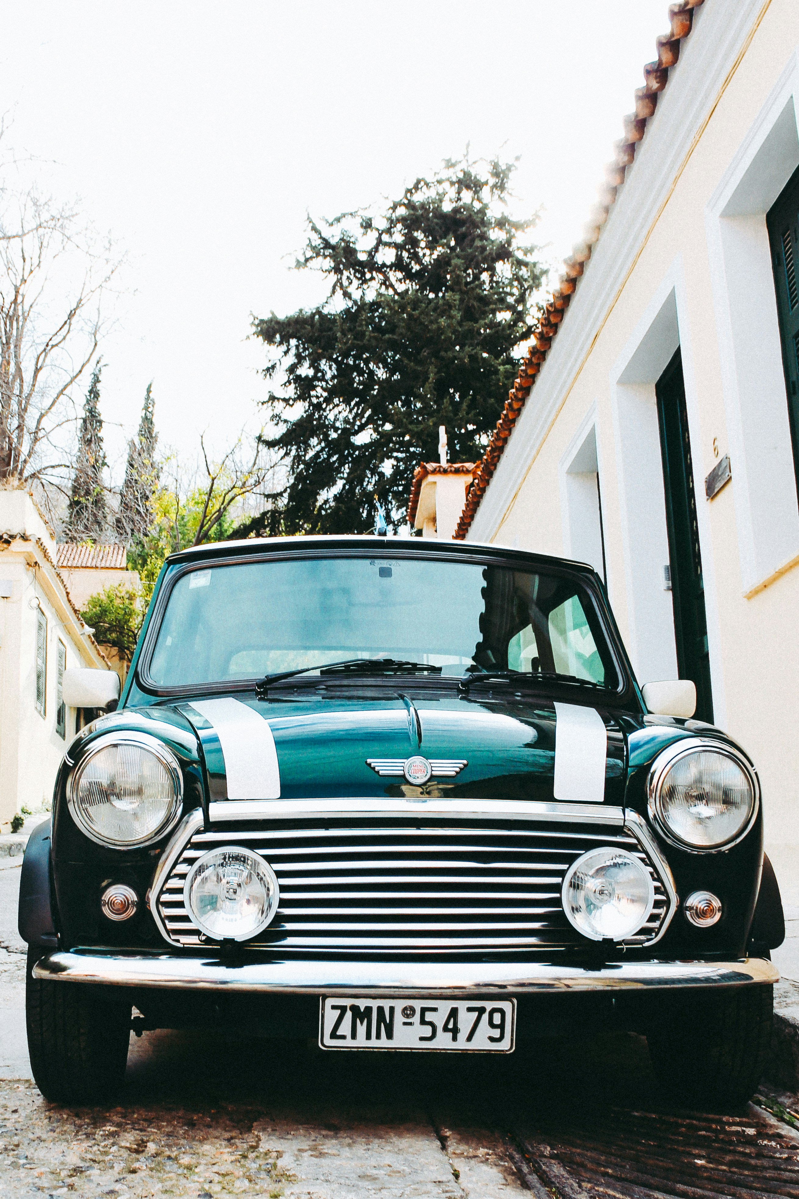 a green and white car parked in front of a house