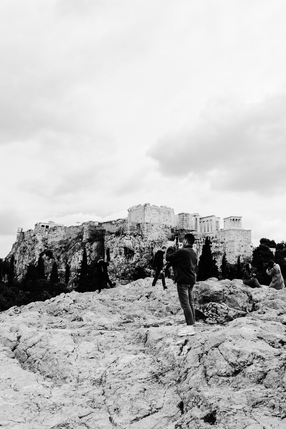 a man standing on top of a rock covered hillside