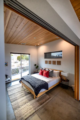 a bedroom with a large bed and a sliding glass door