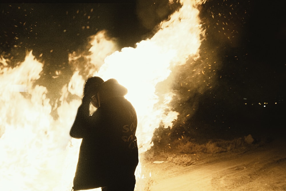 a man standing in front of a large fire