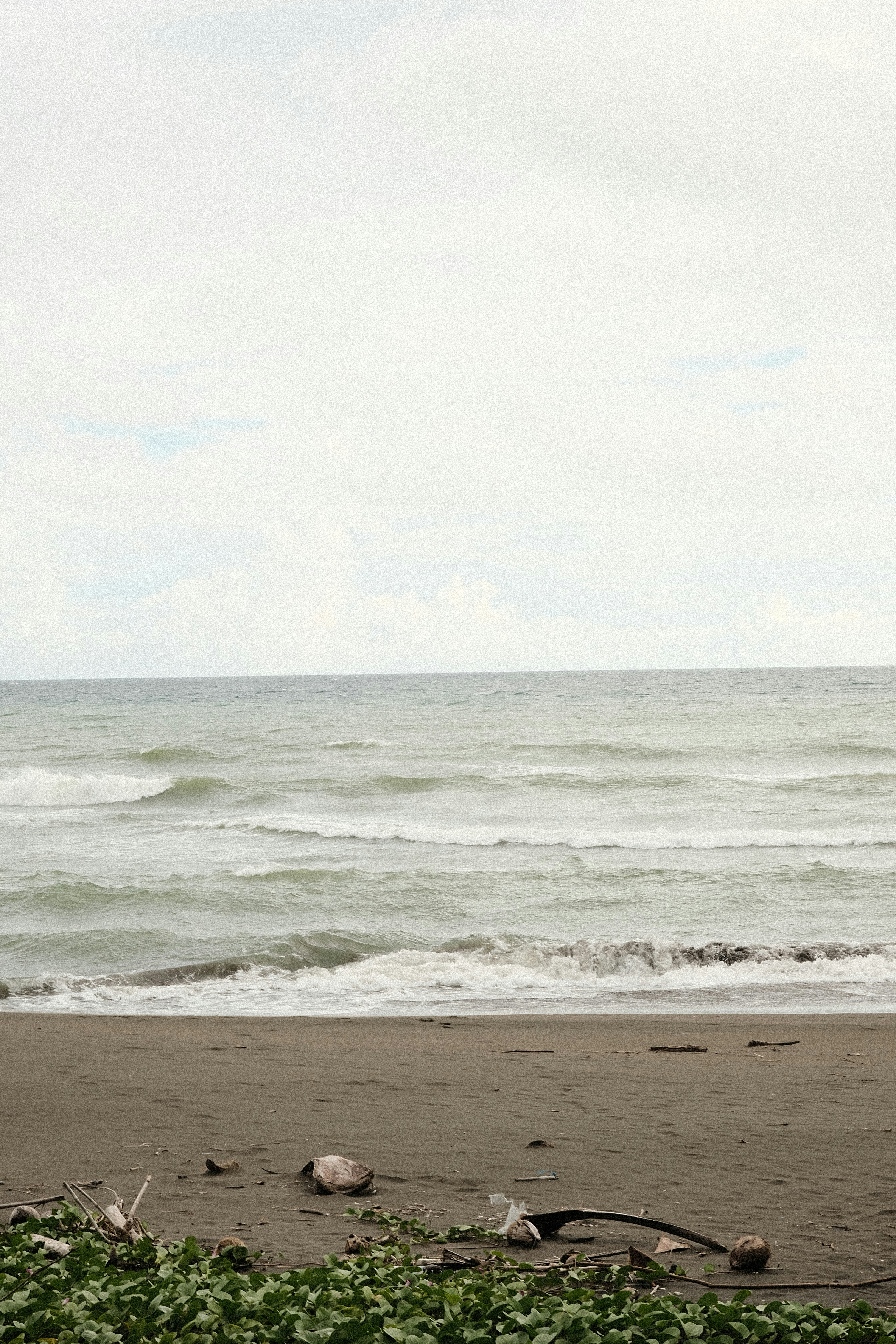 a person walking on a beach carrying a surfboard