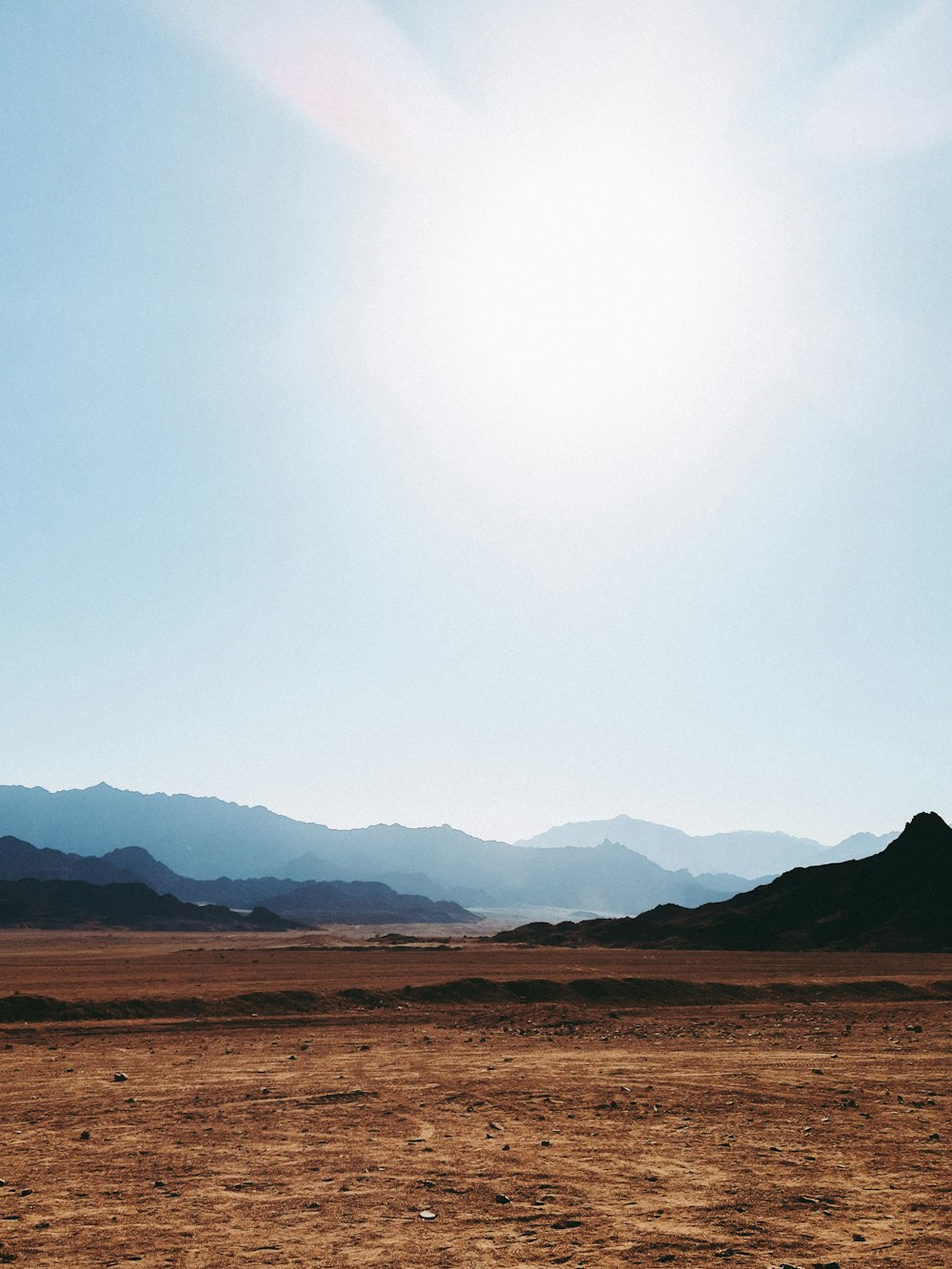 the sun shines brightly over a barren landscape