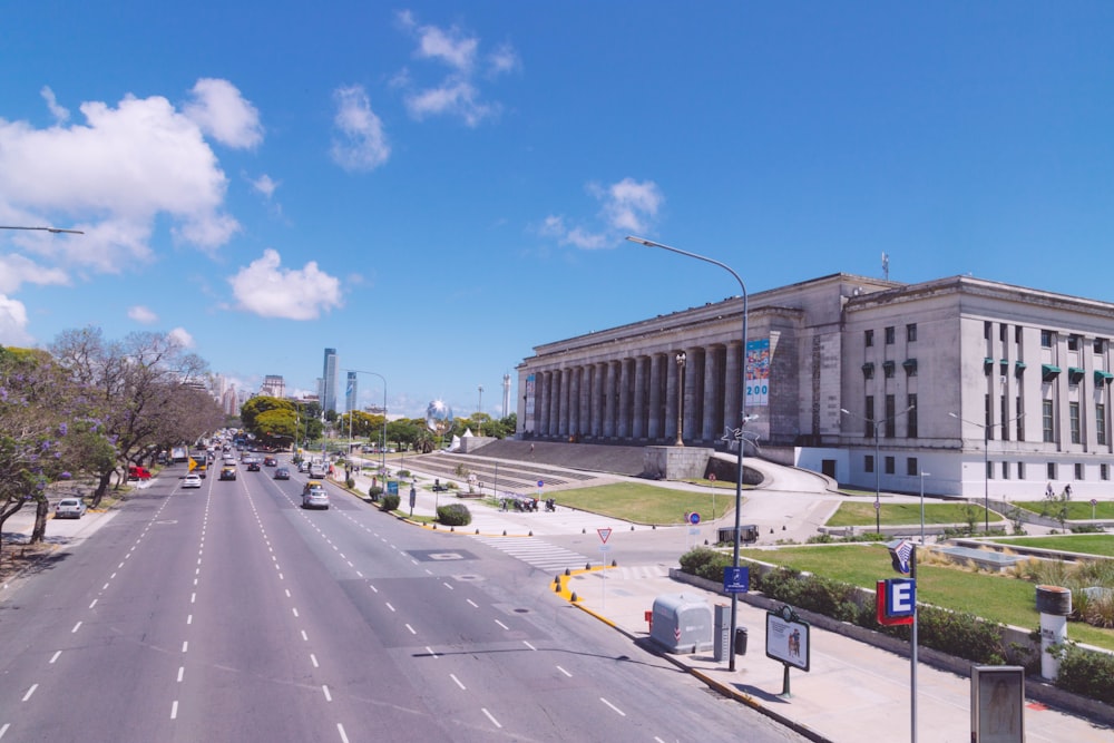 a city street with a large building in the background