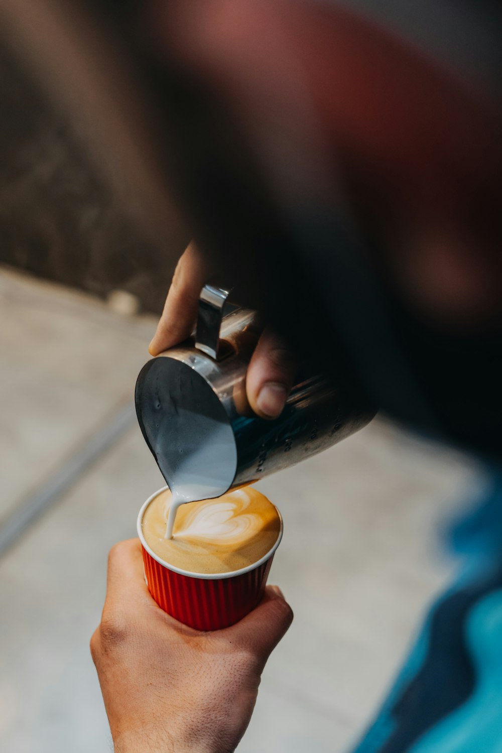 a person is pouring something into a cup