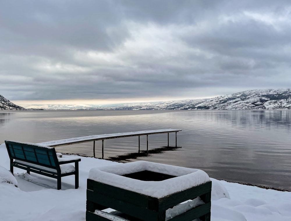 a bench sitting on top of a snow covered ground