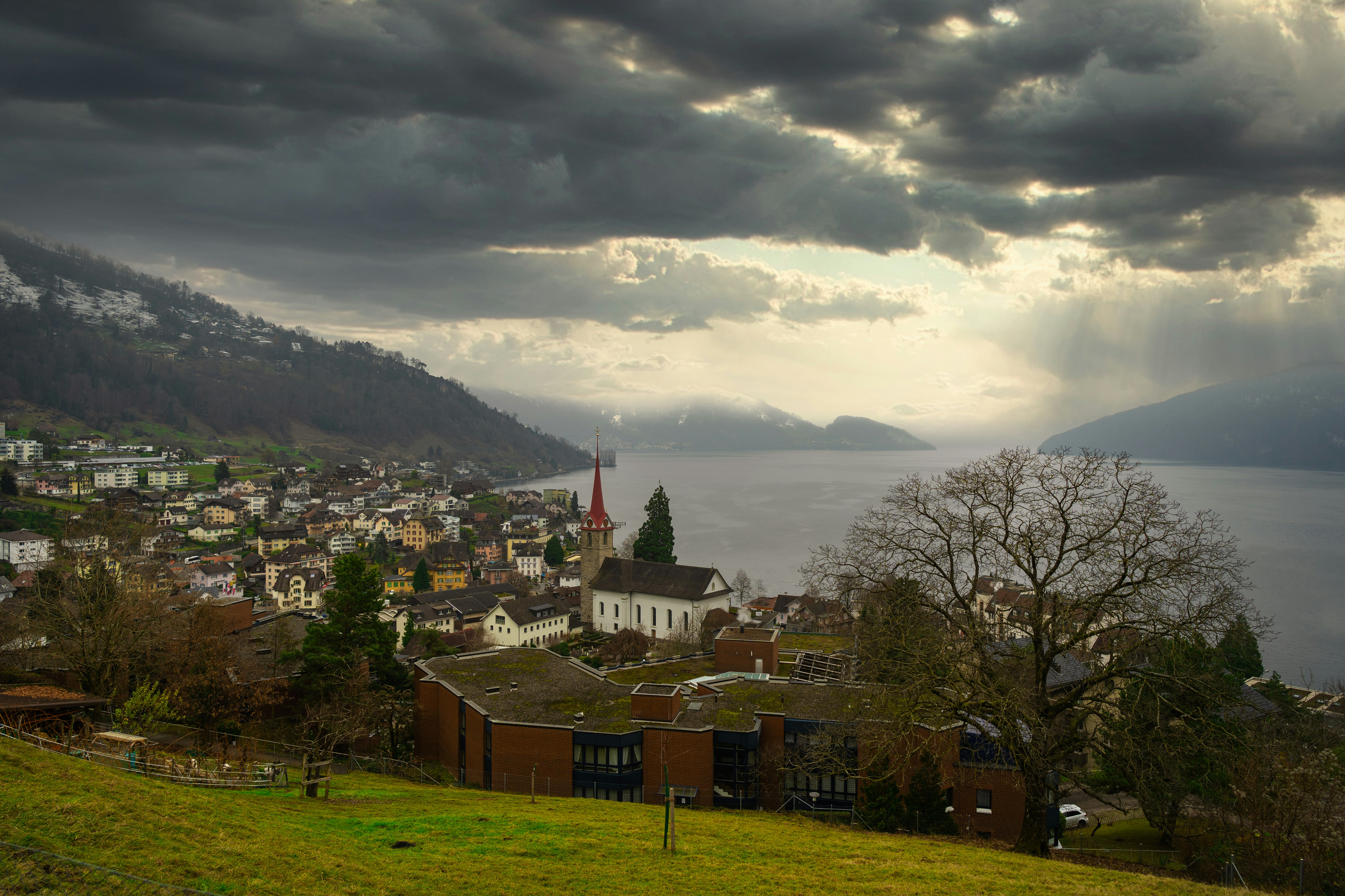 a view of a town with a lake and mountains in the background