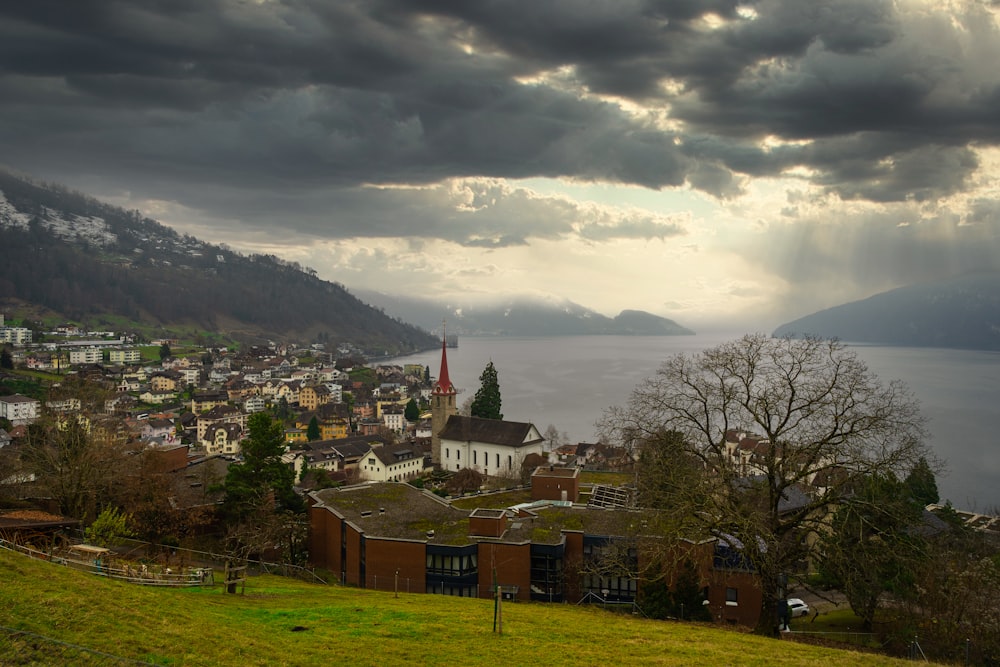 a view of a town with a lake and mountains in the background