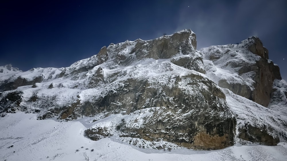 a mountain covered in snow under a blue sky