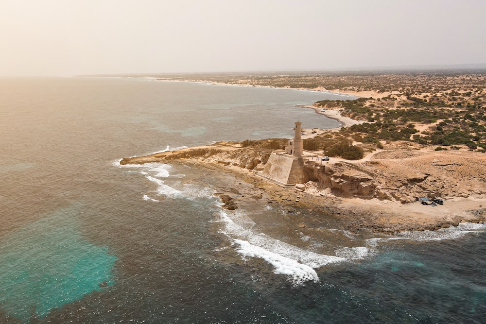 an aerial view of an island with a lighthouse