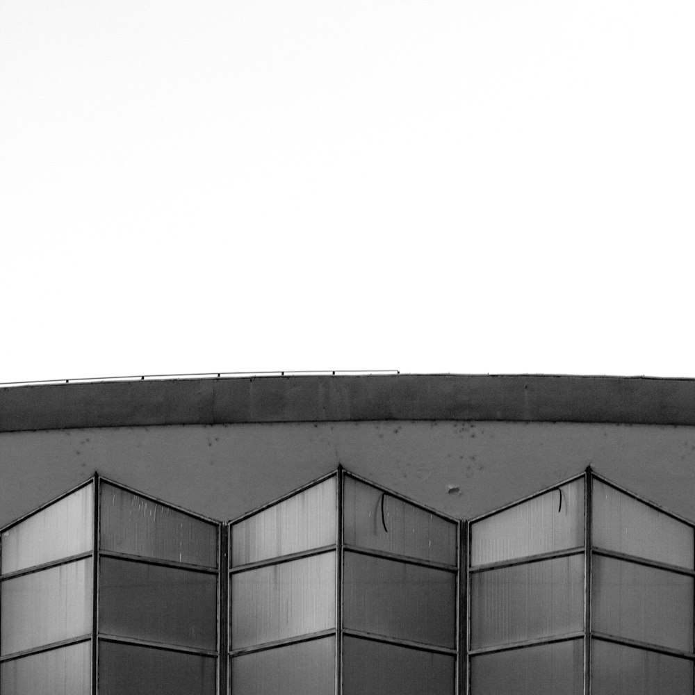 a black and white photo of an airplane flying over a building