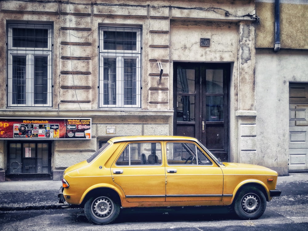 a yellow car parked in front of a building