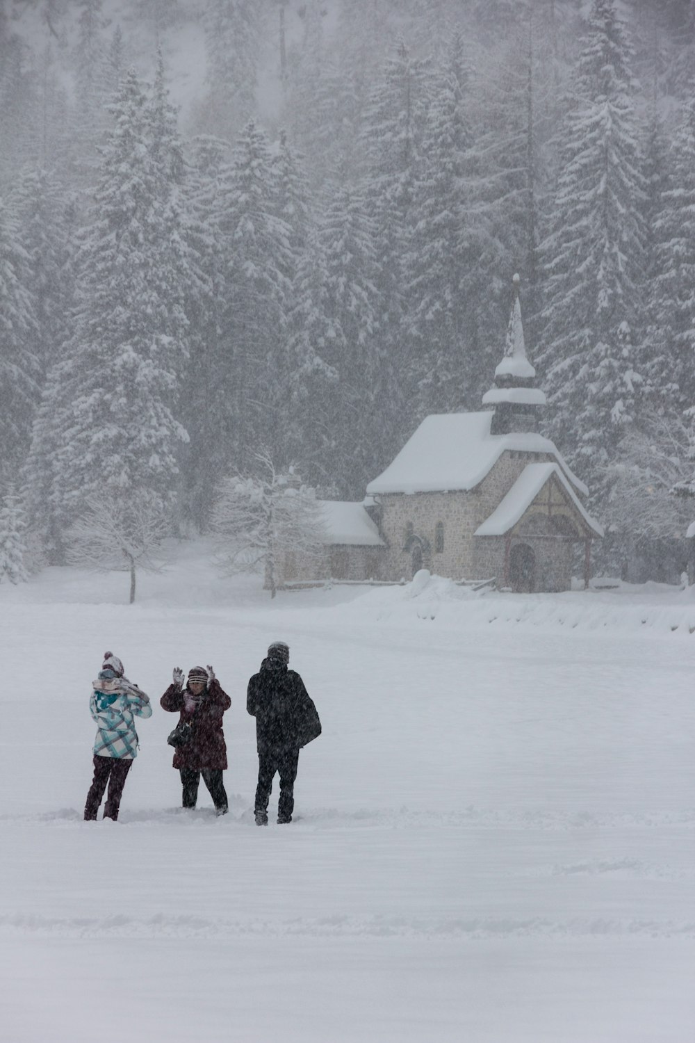 a group of people walking through a snow covered field