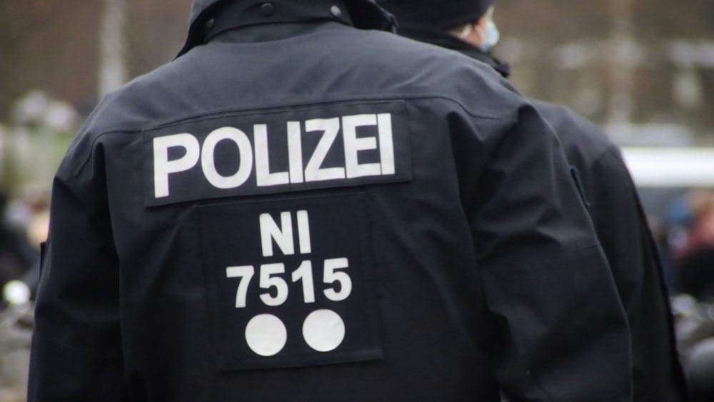 a police officer wearing a black jacket with white numbers on it